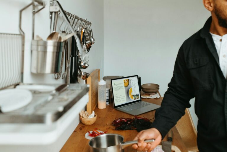 Person preparing sandwiches modern kitchen tablet recipe app