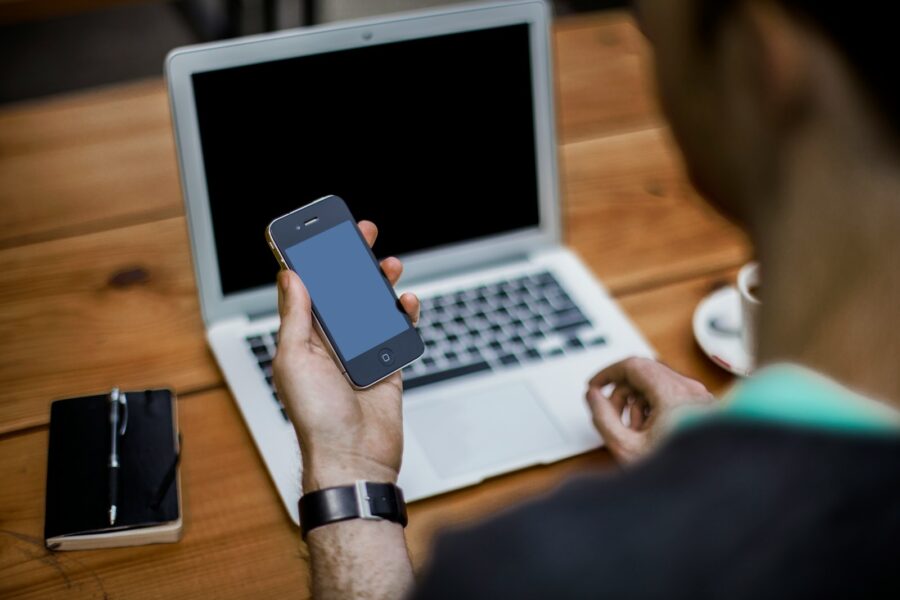 Person taking screenshot laptop smartphone desk