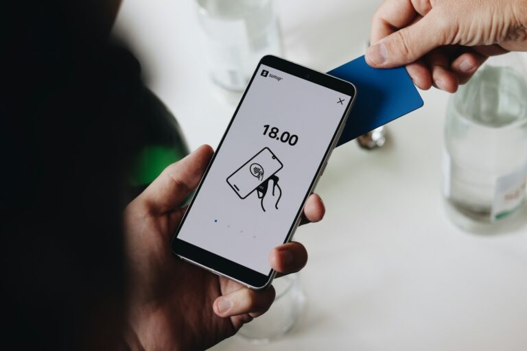 Person checking data breach email smartphone bank card