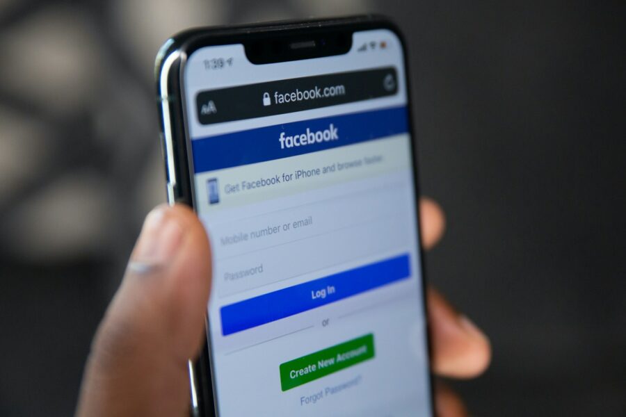 Person holding smartphone facebook app closeup